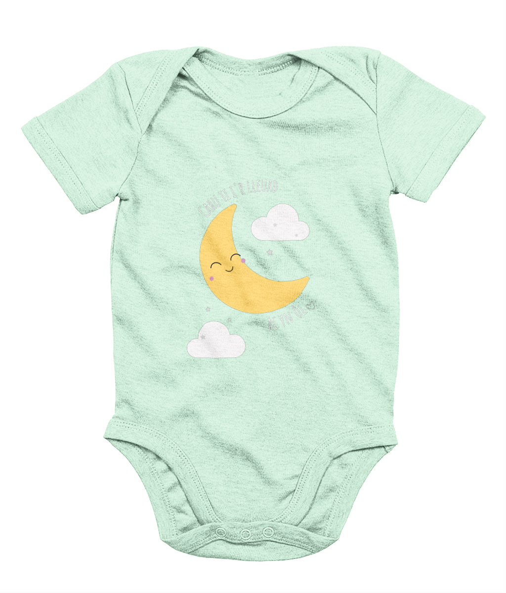 A mint babygrow with a graphic print of a crescent moon and clouds, and the phrase 'Caru Ti i’r Lleuad' printed on the front.