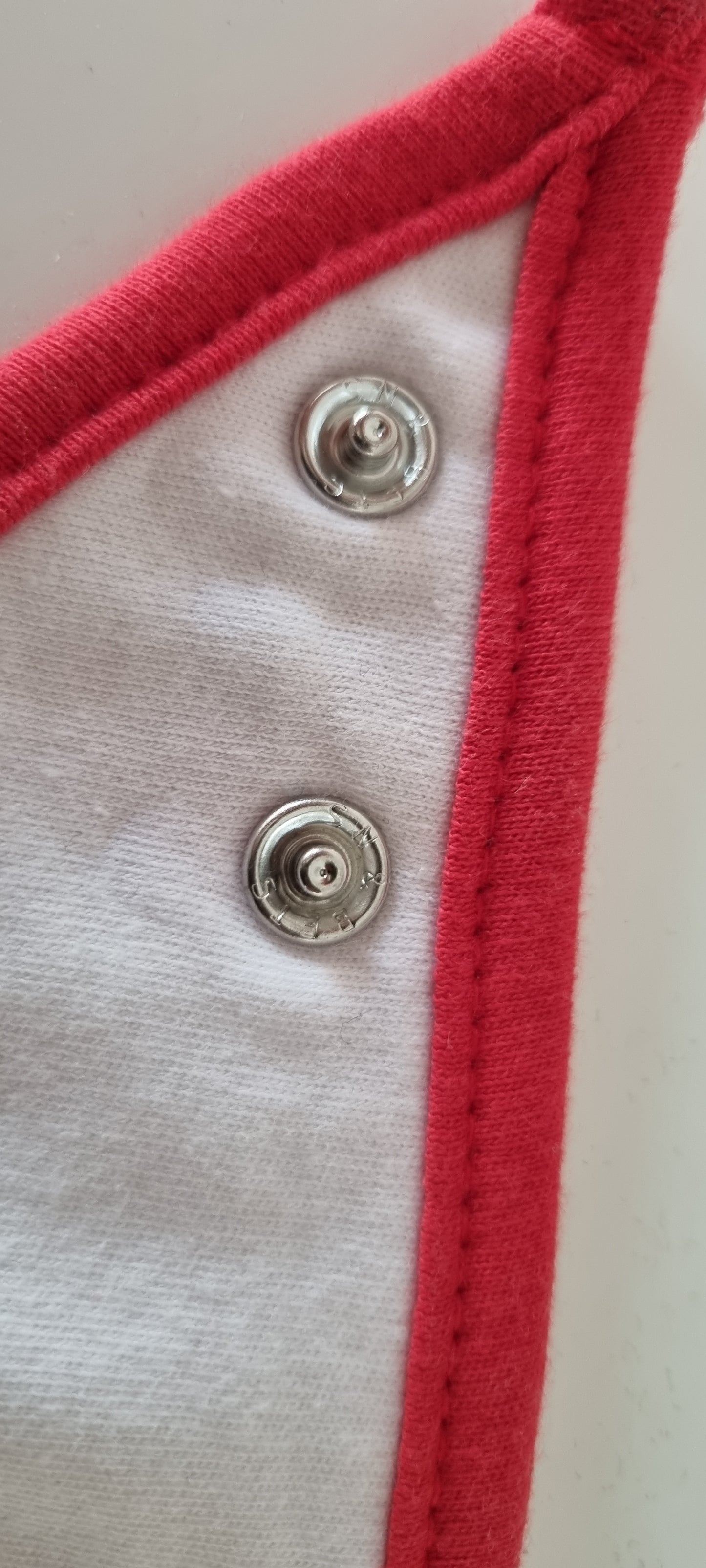 Close-up of a button on a red and white fabric edge.
