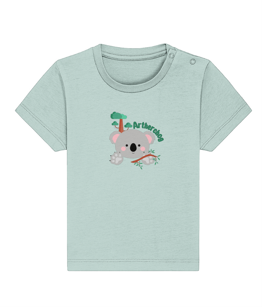 A blue baby t-shirt with a graphic of a koala and a Welsh slogan, made from organic ringspun combed cotton.