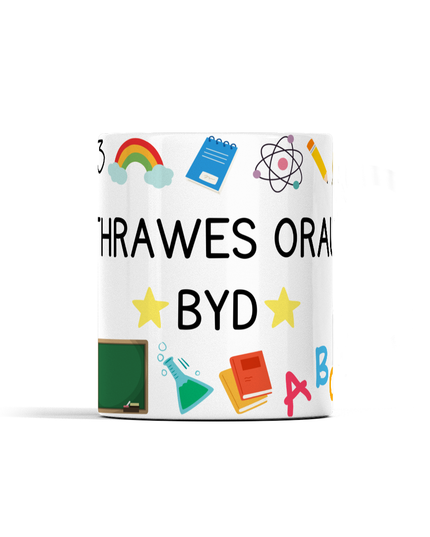 A white ceramic mug with a bold wraparound design featuring Welsh text and various colorful icons related to education.