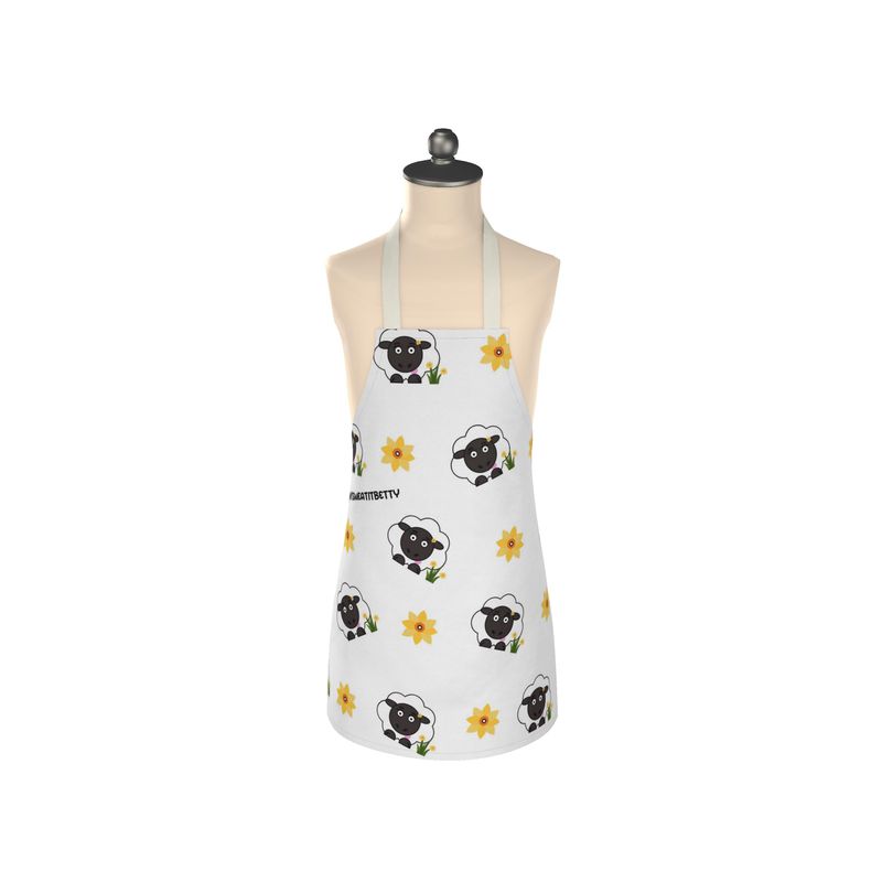 A white apron with a floral pattern featuring black sheep designs, displayed on a mannequin.