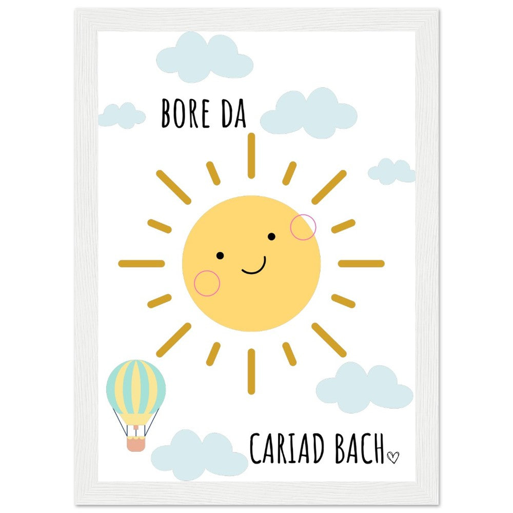 A colorful framed poster featuring a smiling sun with the Welsh phrase 'Bore Da Cariad Bach' and a small hot air balloon.