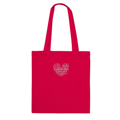 A red cotton tote bag with 'Calon Lân' embroidered on the front, featuring Welsh text within a heart shape.