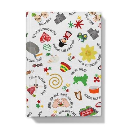 A hardback journal with a colorful cover featuring playful Welsh idioms and symbols.
