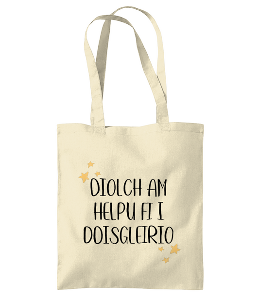 A beige cotton tote bag with the text 'Diolch am helpu fi' printed in black.