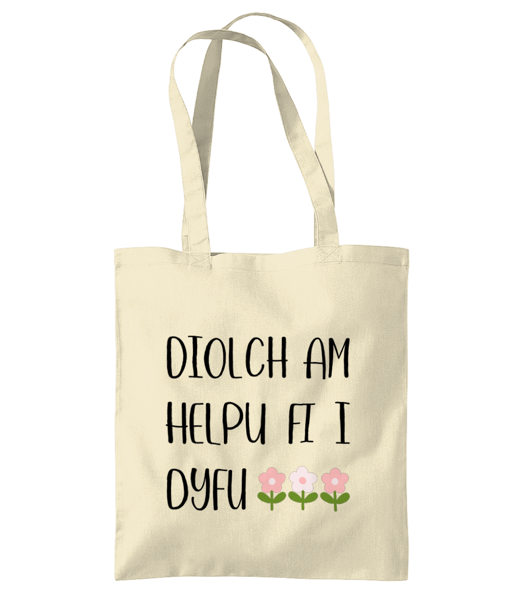 A beige cotton tote bag with the text 'Diolch am helpu fi i dyfu' printed in black.