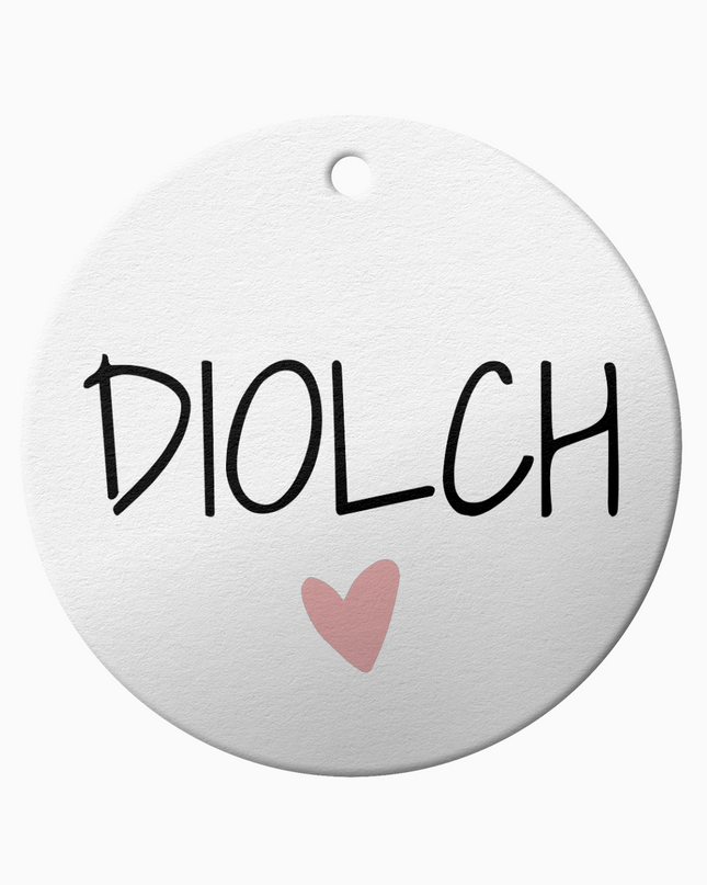 A white ceramic ornament with the Welsh the word 'Diolch' meaning 'thank you'.