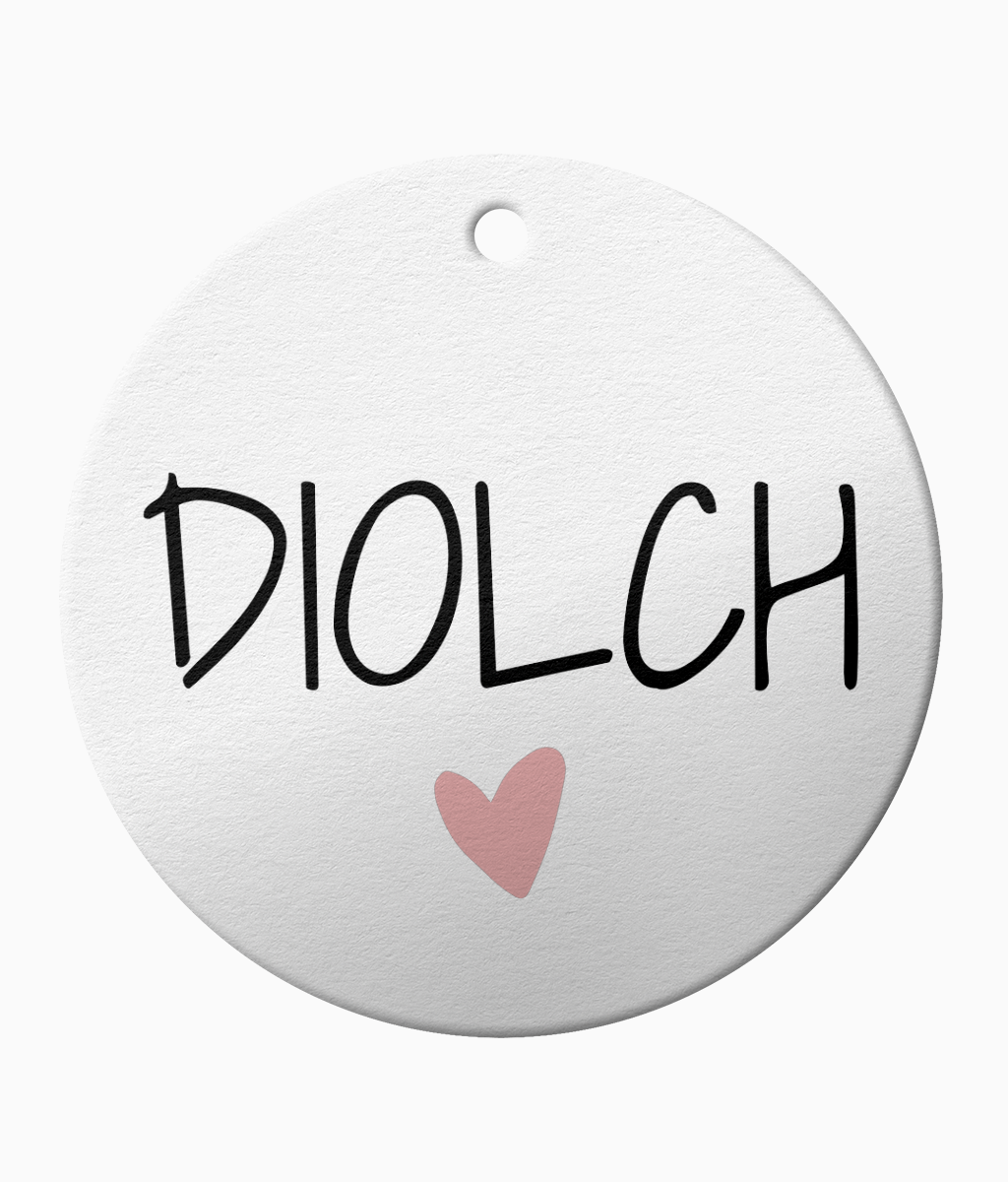 A white ceramic ornament with the Welsh the word 'Diolch' meaning 'thank you'.