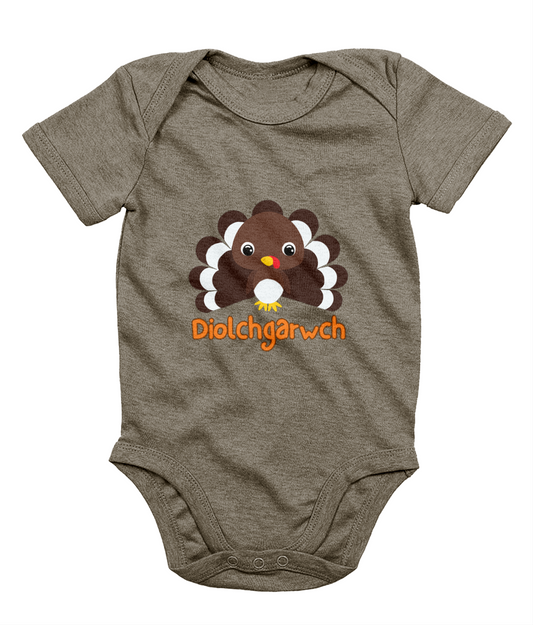 A gray baby bodysuit with a graphic of a Thanksgiving turkey and the text 'Diolchgarwch' printed on the front.