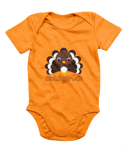 A gray baby bodysuit with a graphic of a Thanksgiving turkey and the text 'Diolchgarwch' printed on the front.