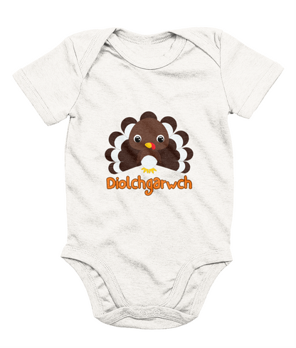A gray baby bodysuit with a graphic of a Thanksgiving turkey and the text 'Diolchgarwch' printed on the front.