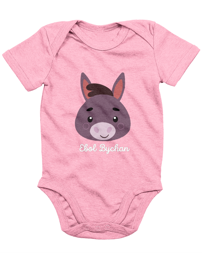 Pink babygrow with a graphic of a donkey's face and the text 'Ebol Bychan' printed on the front.