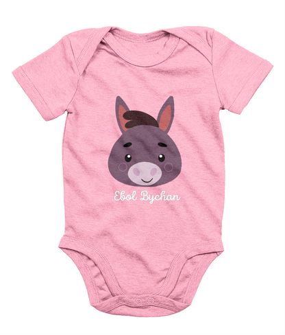 Pink babygrow with a graphic of a donkey's face and the text 'Ebol Bychan' printed on the front.
