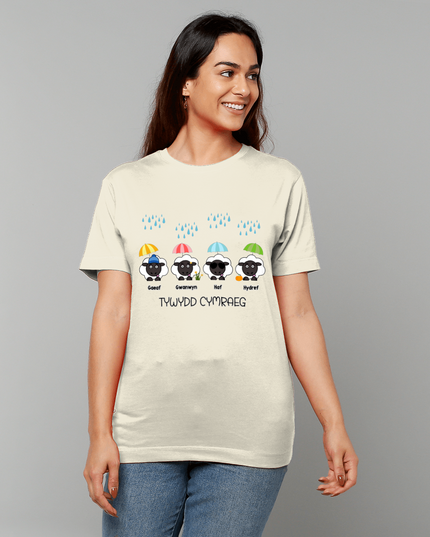 Woman wearing a beige t-shirt with colorful sheep graphics and text on a gray background