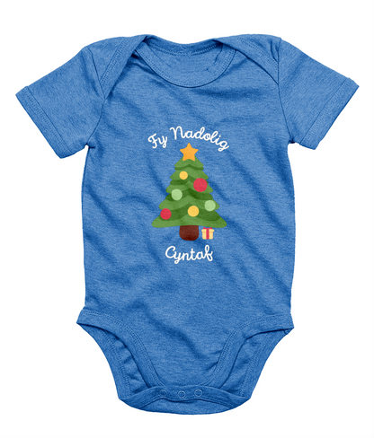 A blue babygro with 'Fy Nadolig Cyntaf' printed in Welsh, featuring a Christmas tree motif.