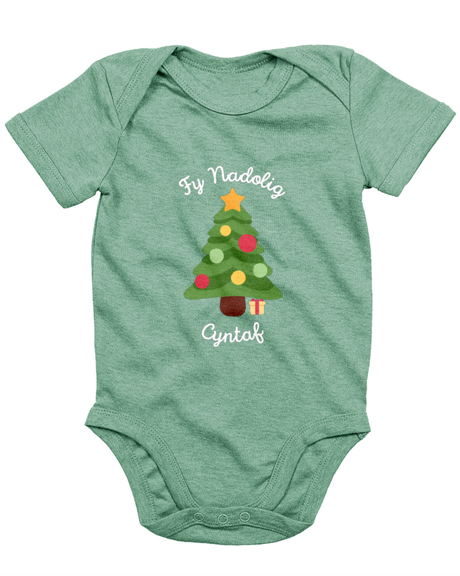 A green babygro with 'Fy Nadolig Cyntaf' printed in Welsh, featuring a Christmas tree motif.