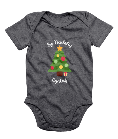 A navy babygro with 'Fy Nadolig Cyntaf' printed in Welsh, featuring a Christmas tree motif.