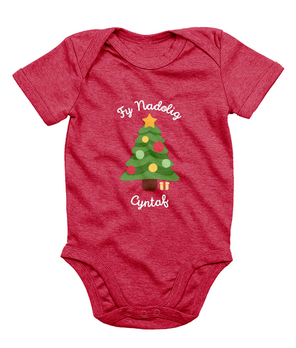 A red babygro with 'Fy Nadolig Cyntaf' printed in Welsh, featuring a Christmas tree motif.