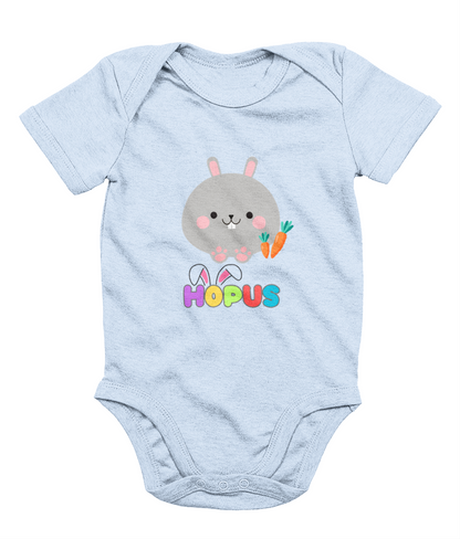 A blue babygrow with a graphic of a grey bunny and the text 'HOPUS' in bold, stylized lettering. The bunny has ears and carrots, suggesting a playful, Easter-themed design.