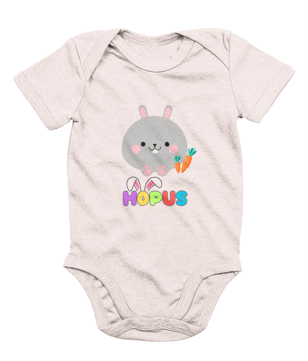 A pink babygrow with a graphic of a grey bunny and the text 'HOPUS' in bold, stylized lettering. The bunny has ears and carrots, suggesting a playful, Easter-themed design.
