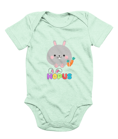 A green babygrow with a graphic of a grey bunny and the text 'HOPUS' in bold, stylized lettering. The bunny has ears and carrots, suggesting a playful, Easter-themed design.