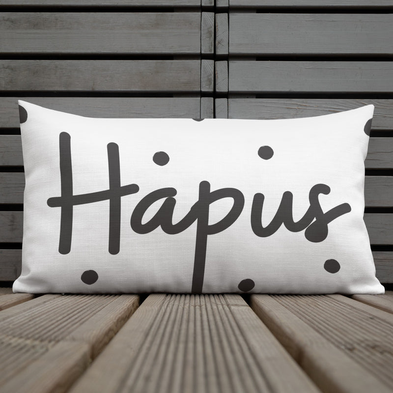A premium pillow with a Welsh themed design, featuring text in Welsh on a sofa in a room with decorative plants and wooden furniture.