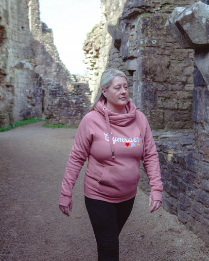 Woman in a pink hoodie walking through stone ruins