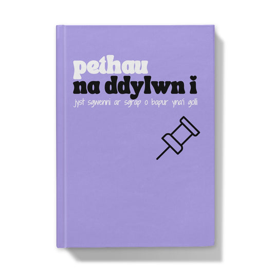 A purple hardback journal with Welsh text on the cover, translates to 'things I shouldn't write on a scrap of paper then lose'.