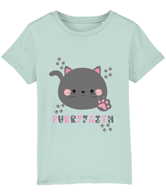 A light-colored girls' t-shirt with a graphic of a cartoon cat and the text 'Purrffaith'. The shirt is designed for children and is organic cotton.