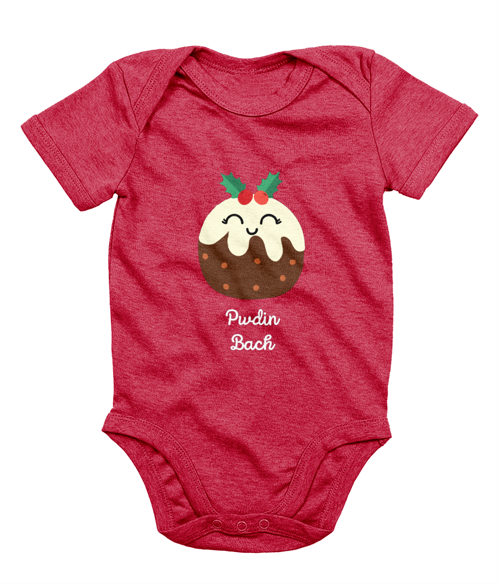 A red sleeveless babygrow with a graphic print of a Christmas pudding and the Welsh phrase 'Pwdin Bach'.