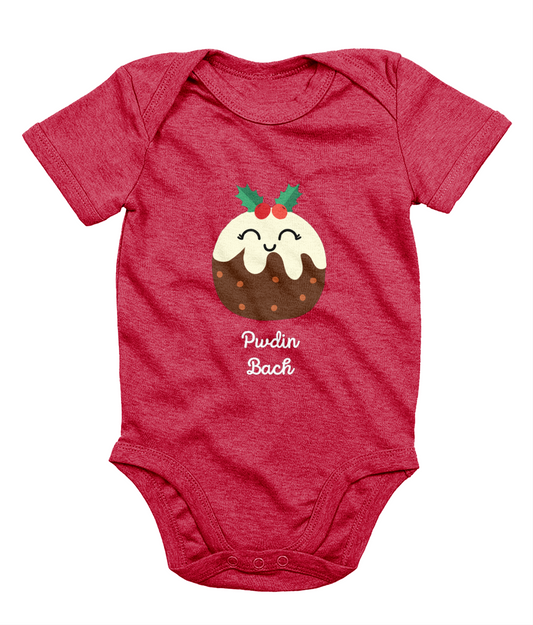 A red sleeveless babygrow with a graphic print of a Christmas pudding and the Welsh phrase 'Pwdin Bach'.