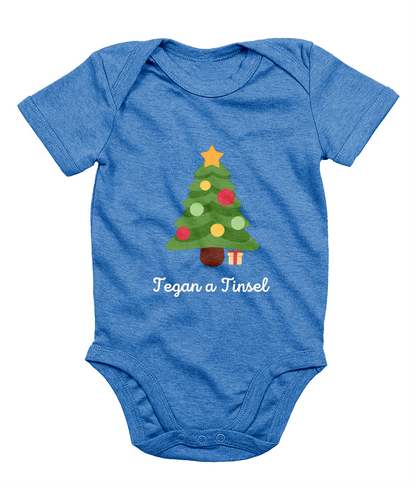 Blue Welsh Christmas-themed babygrow with a Christmas tree and gifts design, and the text 'Tegannau a Tinsel' printed on the front.
