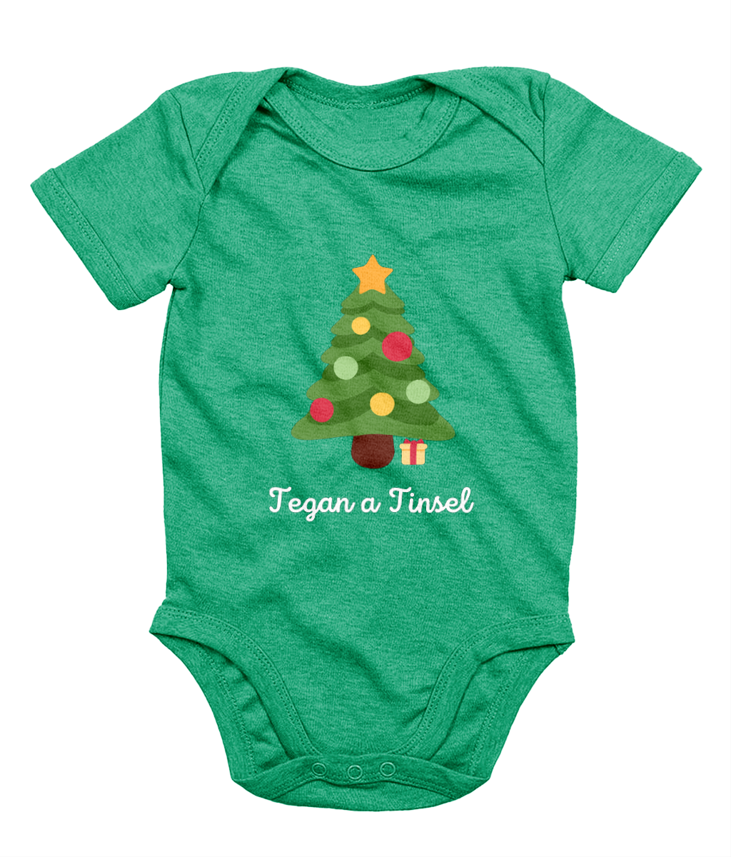 Green Welsh Christmas-themed babygrow with a Christmas tree and gifts design, and the text 'Tegannau a Tinsel' printed on the front.