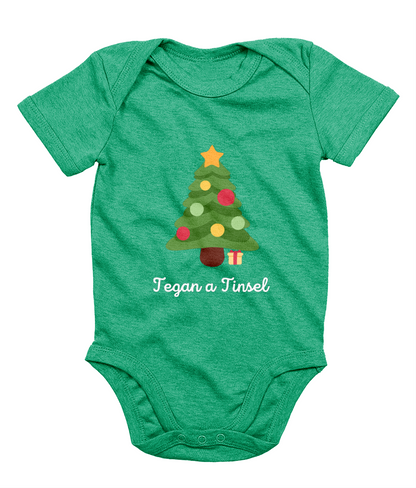Green Welsh Christmas-themed babygrow with a Christmas tree and gifts design, and the text 'Tegannau a Tinsel' printed on the front.