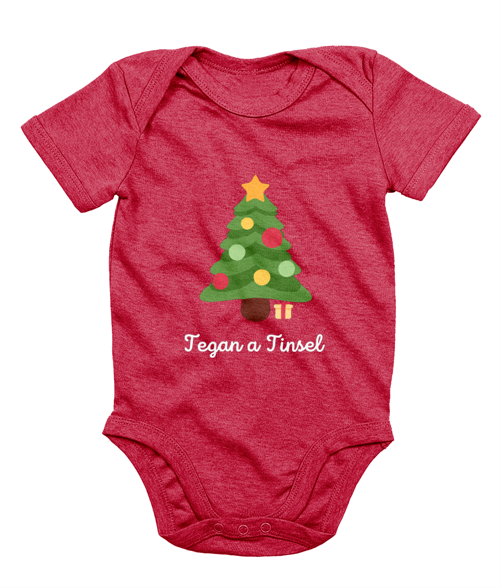 Red Welsh Christmas-themed babygrow with a Christmas tree and gifts design, and the text 'Tegannau a Tinsel' printed on the front.