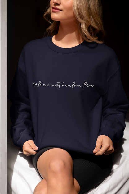 A woman smiling and wearing a navy sweatshirt with the embroidered text 'calon onest calon lan' in white.