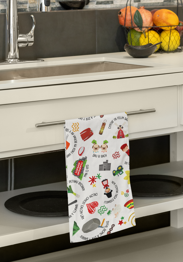Kitchen towel with colorful designs hanging on a cabinet door